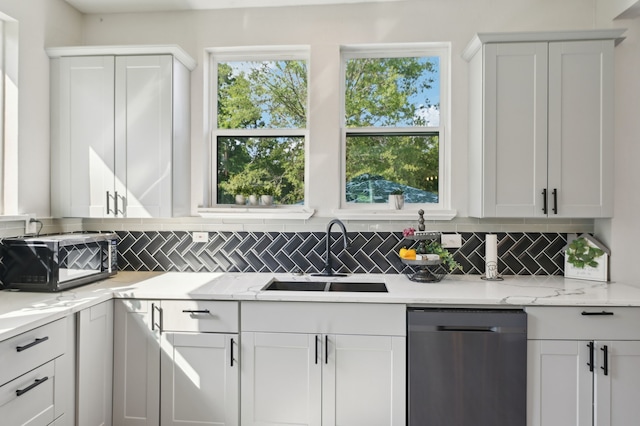 702 Griffith, Terrell, TX 75160 - kitchen with stainless steel dishwasher, a sink, decorative backsplash, white cabinets, and light stone counters