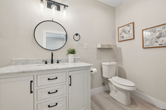 702 Griffith, Terrell, TX 75160 - half bathroom with vanity, wood finished floors, toilet, and baseboards