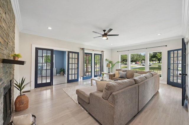 702 Griffith, Terrell, TX 75160 - living area featuring french doors, a stone fireplace, light wood-style floors, ornamental molding, and a ceiling fan