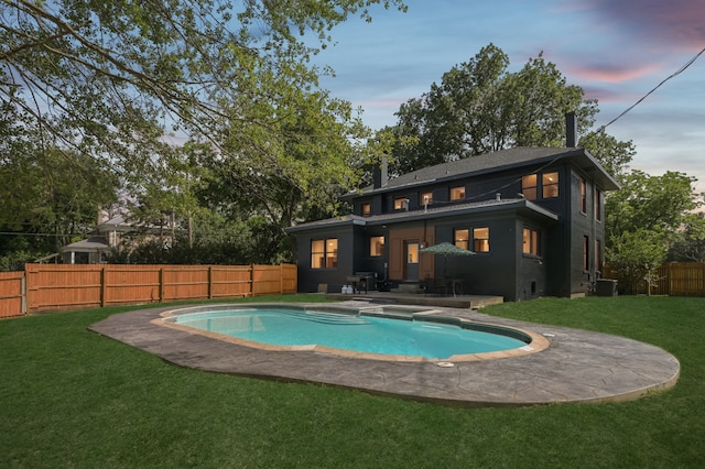 702 Griffith, Terrell, TX 75160 - back of house at dusk with a patio area, central AC, a chimney, and a pool with connected hot tub