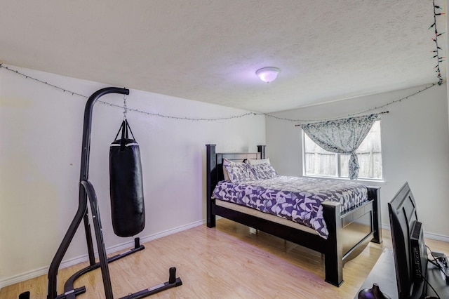 3110 Nutmeg Ln, Garland, TX 75044 - bedroom with light wood-style floors, baseboards, and a textured ceiling