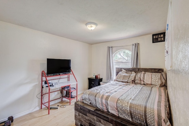 3110 Nutmeg Ln, Garland, TX 75044 - bedroom with baseboards, wood finished floors, and a textured ceiling