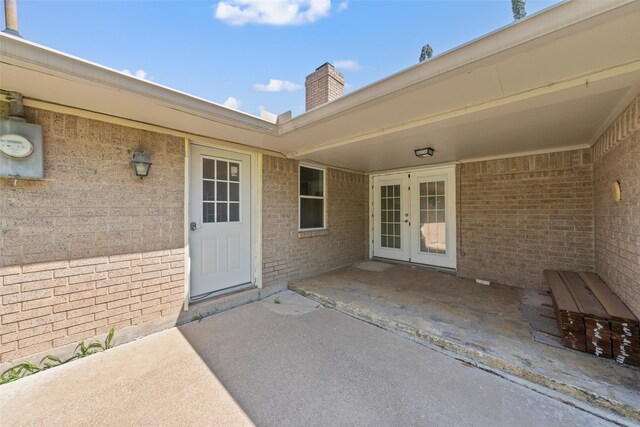1812 Trinity Dr, Waco, TX 76710 - doorway to property featuring french doors, a patio area, a chimney, and brick siding