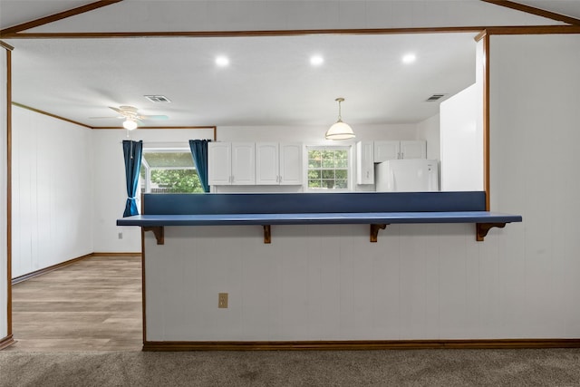 1812 Trinity Dr, Waco, TX 76710 - kitchen with fridge, a breakfast bar, dark countertops, white cabinets, and healthy amount of natural light
