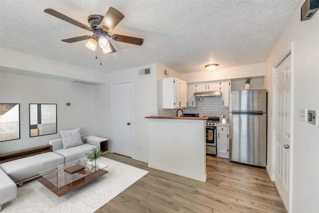 2301 Balsam Dr Unit F308, Arlington, TX 76006 - kitchen with appliances with stainless steel finishes, a textured ceiling, light wood-style flooring, ceiling fan, and white cabinets
