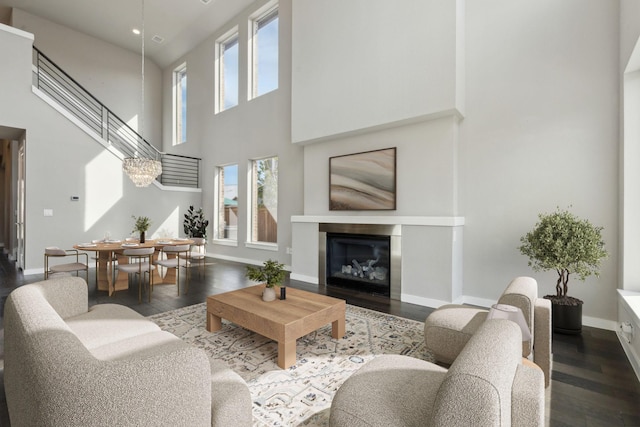 3967 Sanders Dr, Celina, TX 75009 - living room with a high ceiling, wood finished floors, baseboards, a glass covered fireplace, and stairway