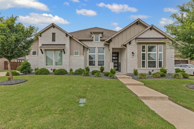 1318 Middleton Dr, Rockwall, TX 75087 - view of front facade featuring board and batten siding, brick siding, and a front lawn