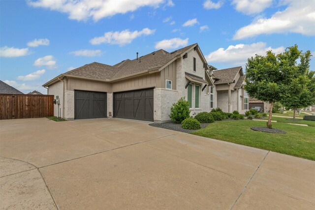 1318 Middleton Dr, Rockwall, TX 75087 - view of side of property featuring a garage, concrete driveway, a shingled roof, brick siding, and board and batten siding