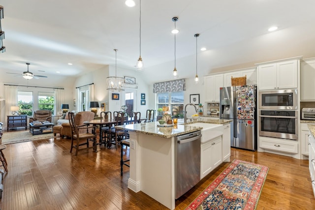 821 Mildren Ln, Fate, TX 75087 - kitchen with appliances with stainless steel finishes, a sink, a ceiling fan, recessed lighting, and light stone counters