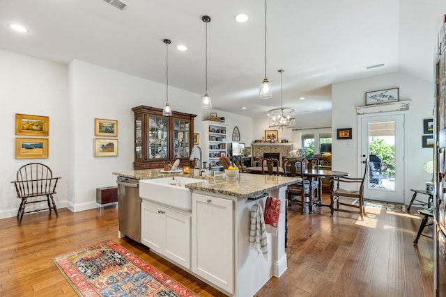 821 Mildren Ln, Fate, TX 75087 - kitchen with dishwasher, a sink, hardwood / wood-style flooring, light stone counters, and white cabinets