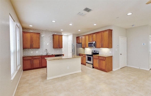 6407 Capulet Pl, Dallas, TX 75252 - kitchen with appliances with stainless steel finishes, decorative backsplash, recessed lighting, a kitchen island, and brown cabinets