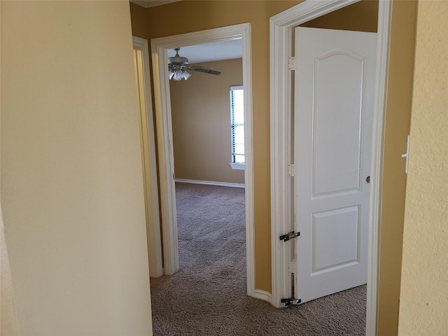 corridor with carpet flooring and baseboards