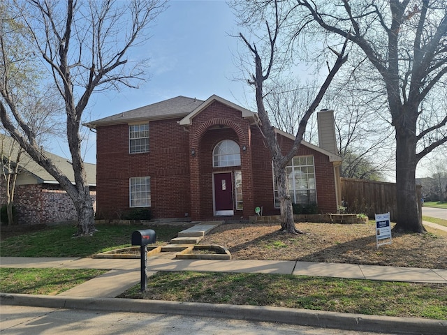 traditional home with brick siding, a chimney, and fence