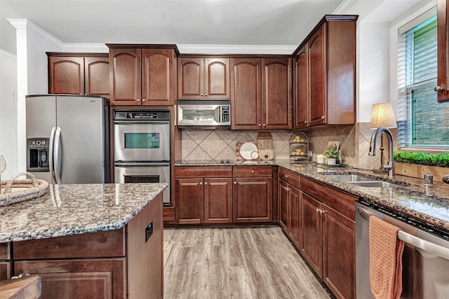 1600 Templegate Dr, Mckinney, TX 75072 - kitchen with stainless steel appliances, stone countertops, a sink, light wood-style flooring, and ornamental molding