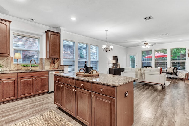 1600 Templegate Dr, Mckinney, TX 75072 - kitchen with a sink, dishwasher, light wood finished floors, a center island, and light stone counters