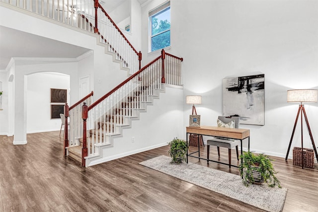 1600 Templegate Dr, Mckinney, TX 75072 - stairway with a towering ceiling, arched walkways, wood finished floors, baseboards, and ornamental molding