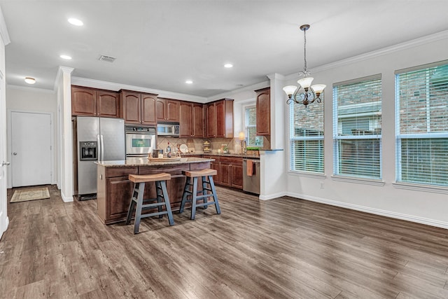 1600 Templegate Dr, Mckinney, TX 75072 - kitchen featuring stainless steel appliances, crown molding, a chandelier, dark wood-style floors, and a kitchen island