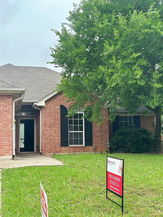 803 W Lonesome Dove Trl, Arlington, TX 76001 - view of front of property featuring a front lawn, brick siding, and a patio