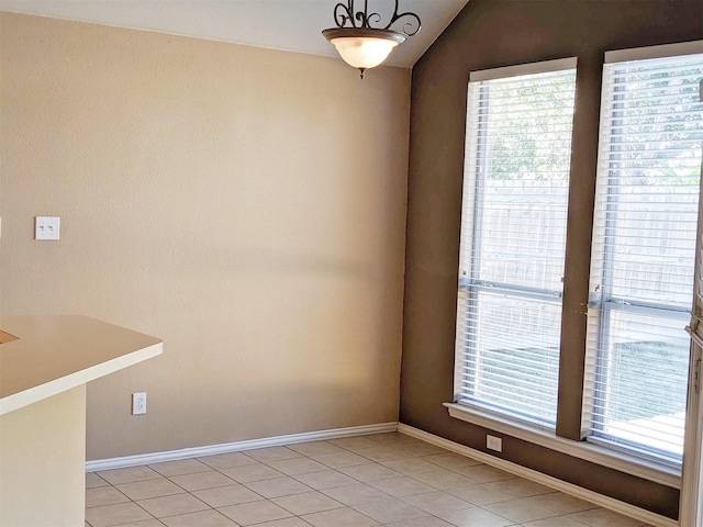 803 W Lonesome Dove Trl, Arlington, TX 76001 - unfurnished dining area featuring plenty of natural light, light tile patterned floors, baseboards, and lofted ceiling