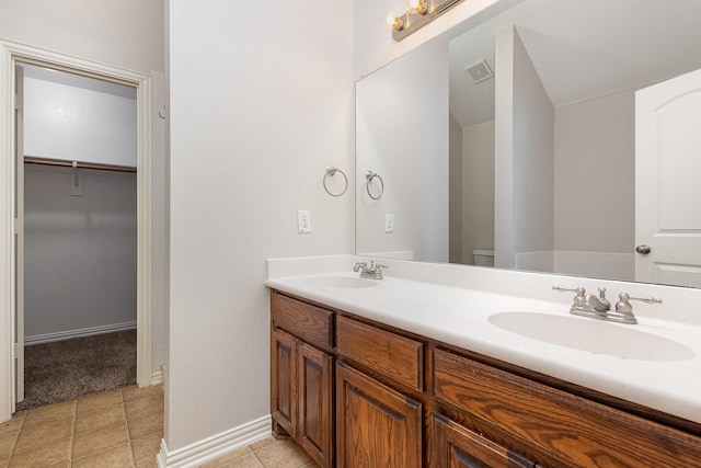 213 Longhorn Dr, Waxahachie, TX 75165 - bathroom with tile patterned flooring, double vanity, a walk in closet, and toilet