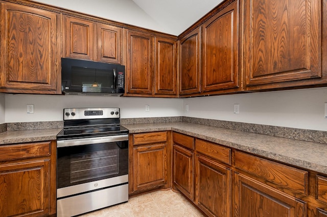 213 Longhorn Dr, Waxahachie, TX 75165 - kitchen featuring black microwave, electric range, vaulted ceiling, dark countertops, and light tile patterned flooring