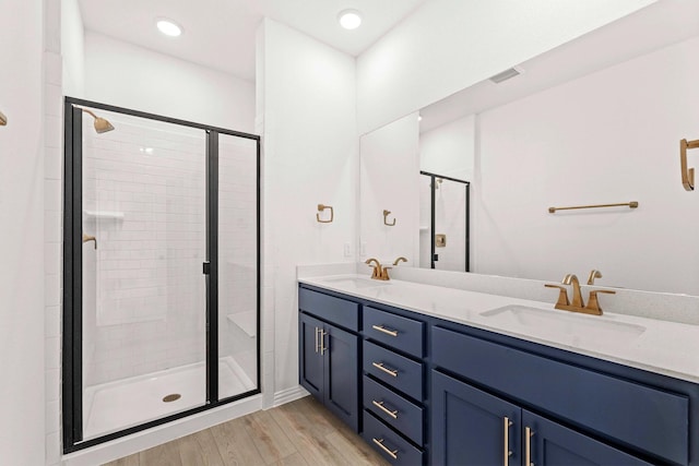 1126 Bexar Ln, Plano, TX 75075 - bathroom featuring a shower stall, wood finished floors, and double vanity