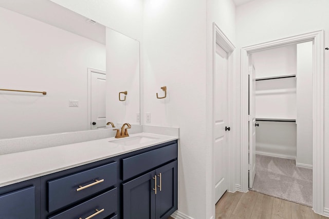 1126 Bexar Ln, Plano, TX 75075 - bathroom featuring wood finished floors, vanity, and a spacious closet