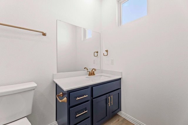 1126 Bexar Ln, Plano, TX 75075 - bathroom with toilet, vanity, baseboards, and wood finished floors