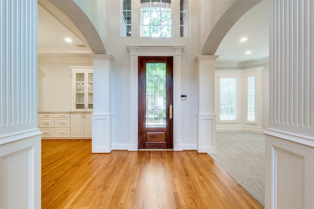 2 Birchmont Ln, Dallas, TX 75230 - foyer with arched walkways, ornamental molding, decorative columns, light wood finished floors, and baseboards