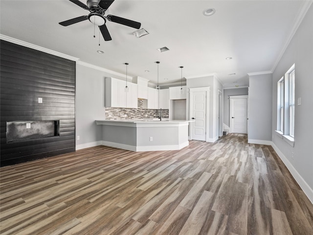 6223 Post Oak Ter, Fort Worth, TX 76112 - unfurnished living room featuring a glass covered fireplace, a sink, ornamental molding, baseboards, and wood finished floors