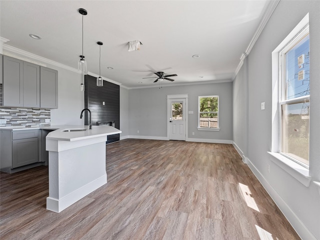 6223 Post Oak Ter, Fort Worth, TX 76112 - kitchen with a sink, gray cabinets, light countertops, crown molding, and decorative backsplash