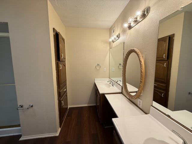 828 Wood Gln, Desoto, TX 75115 - bathroom with wood finished floors, baseboards, a textured ceiling, and vanity