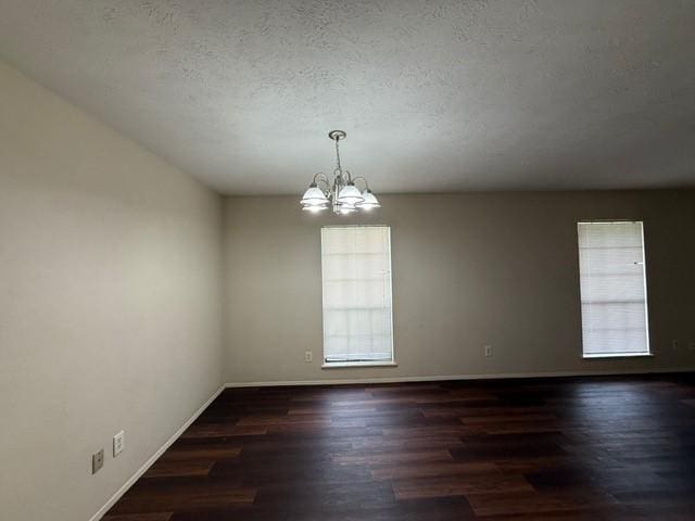 828 Wood Gln, Desoto, TX 75115 - spare room with plenty of natural light, dark wood-style flooring, baseboards, a chandelier, and a textured ceiling