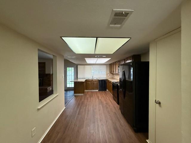 828 Wood Gln, Desoto, TX 75115 - kitchen with black appliances, dark wood finished floors, light countertops, baseboards, and a sink