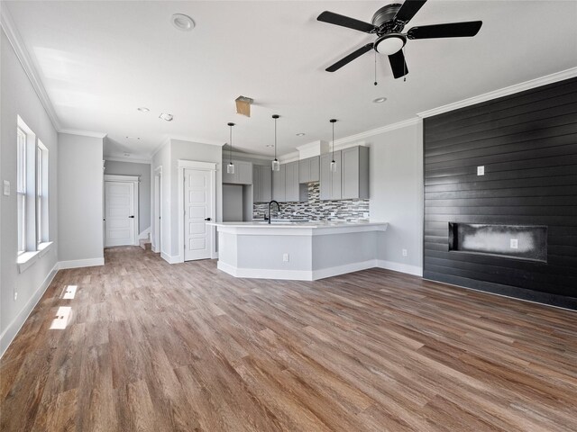 6221 Post Oak Ter, Fort Worth, TX 76112 - unfurnished living room with a glass covered fireplace, wood finished floors, crown molding, a sink, and baseboards