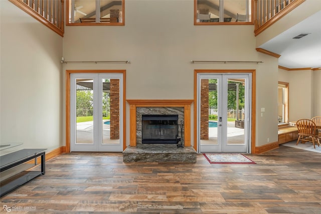 135 Oak Leaf Trl, Benton, LA 71006 - unfurnished living room with french doors, a high ceiling, wood finished floors, healthy amount of natural light, and ornamental molding