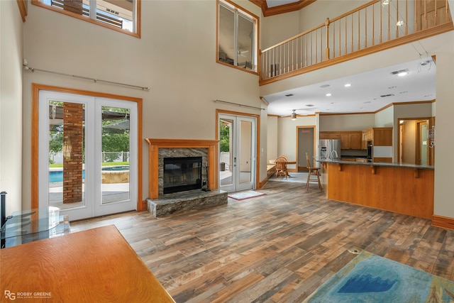 135 Oak Leaf Trl, Benton, LA 71006 - unfurnished living room featuring plenty of natural light, wood finished floors, a high ceiling, crown molding, and french doors