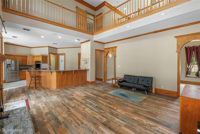 135 Oak Leaf Trl, Benton, LA 71006 - living area featuring crown molding, wood finished floors, a towering ceiling, baseboards, and recessed lighting