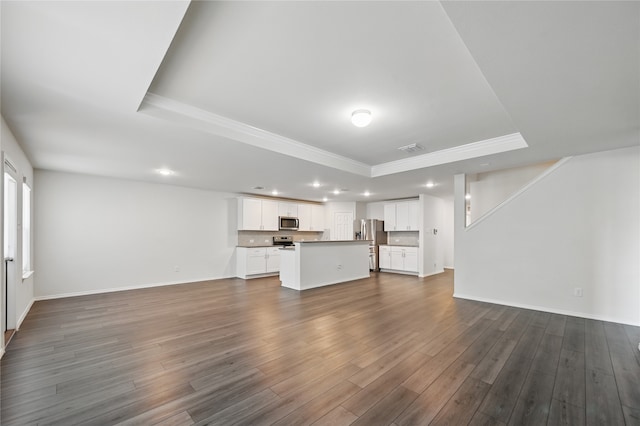 1611 Timpson Dr, Forney, TX 75126 - unfurnished living room featuring a raised ceiling, recessed lighting, ornamental molding, dark wood-type flooring, and baseboards