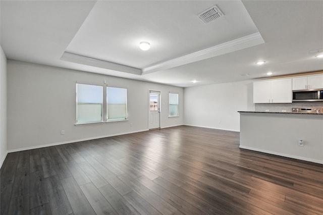 1611 Timpson Dr, Forney, TX 75126 - unfurnished living room with a tray ceiling, recessed lighting, dark wood-type flooring, crown molding, and baseboards