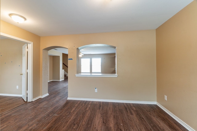 1005 Bainbridge Ln, Forney, TX 75126 - spare room with arched walkways, dark wood-style floors, and baseboards