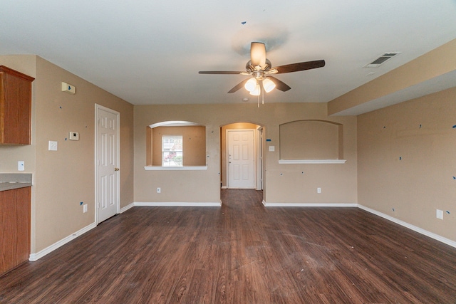 1005 Bainbridge Ln, Forney, TX 75126 - unfurnished living room featuring ceiling fan, dark wood-type flooring, baseboards, and arched walkways