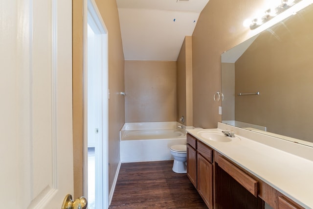 1005 Bainbridge Ln, Forney, TX 75126 - bathroom with vanity, a bath, lofted ceiling, wood finished floors, and toilet