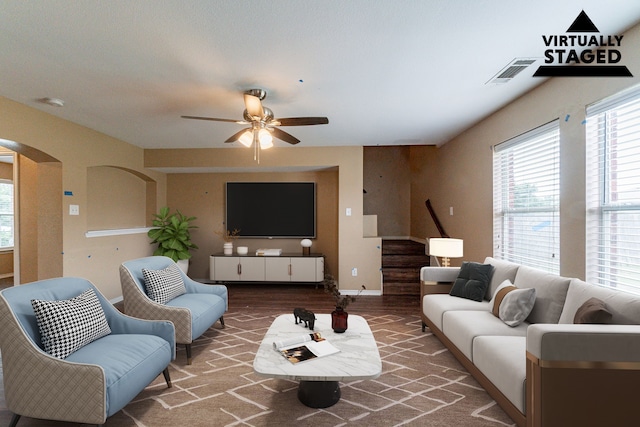 1005 Bainbridge Ln, Forney, TX 75126 - living area with arched walkways, ceiling fan, stairs, wood finished floors, and baseboards