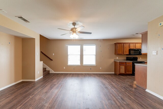1005 Bainbridge Ln, Forney, TX 75126 - kitchen with range with electric cooktop, black microwave, brown cabinets, and dark wood-style flooring