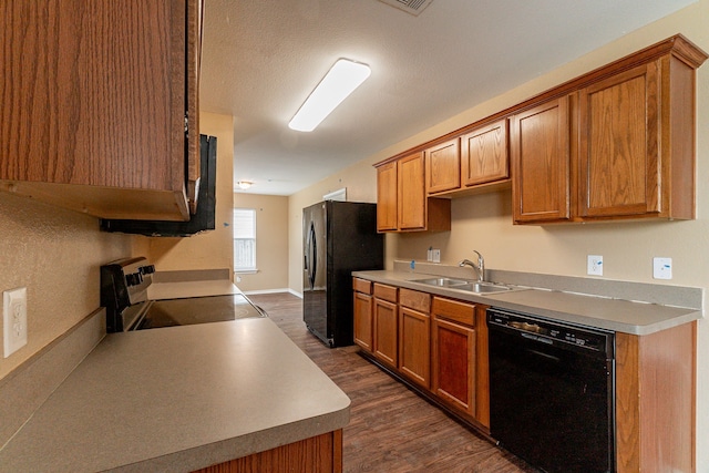 1005 Bainbridge Ln, Forney, TX 75126 - kitchen with black appliances, a sink, dark wood-type flooring, and brown cabinets