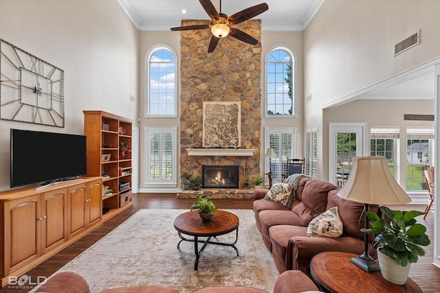 10198 Castanedo Ct, Keithville, LA 71047 - living area featuring dark wood-style flooring, a ceiling fan, a fireplace, a towering ceiling, and crown molding