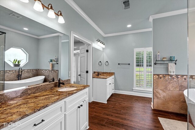 10198 Castanedo Ct, Keithville, LA 71047 - full bathroom featuring a freestanding tub, ornamental molding, wood finished floors, two vanities, and recessed lighting