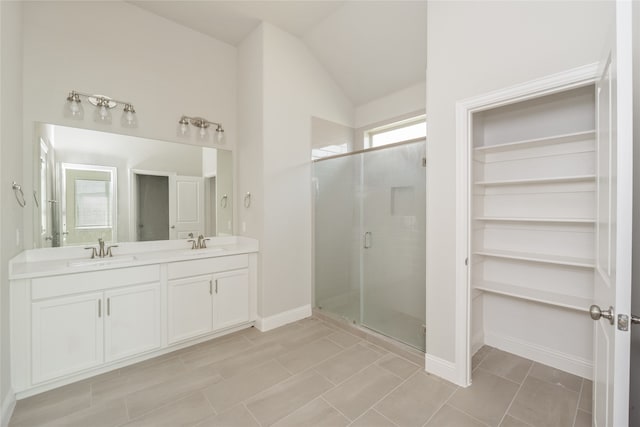 2614 Dakota Cir, Corinth, TX 76210 - bathroom featuring a stall shower, lofted ceiling, double vanity, baseboards, and a spacious closet