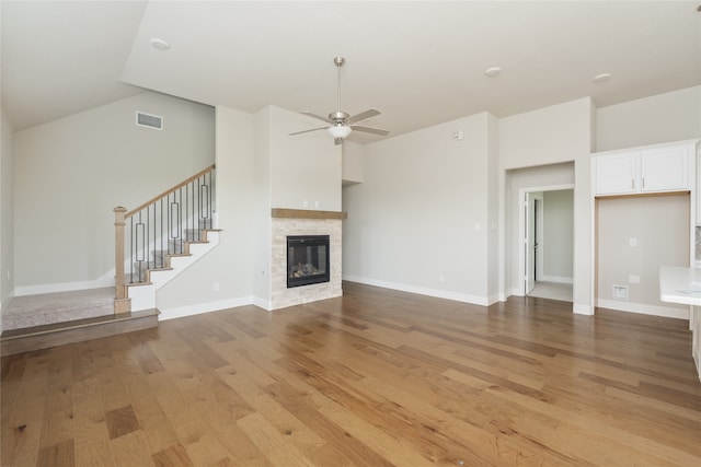 2614 Dakota Cir, Corinth, TX 76210 - unfurnished living room with light wood-type flooring, a ceiling fan, a fireplace, stairs, and baseboards